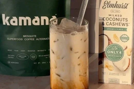 Iced latte made with Kamana mesquite coffee and coconut-cashew milk, with product packaging in the background